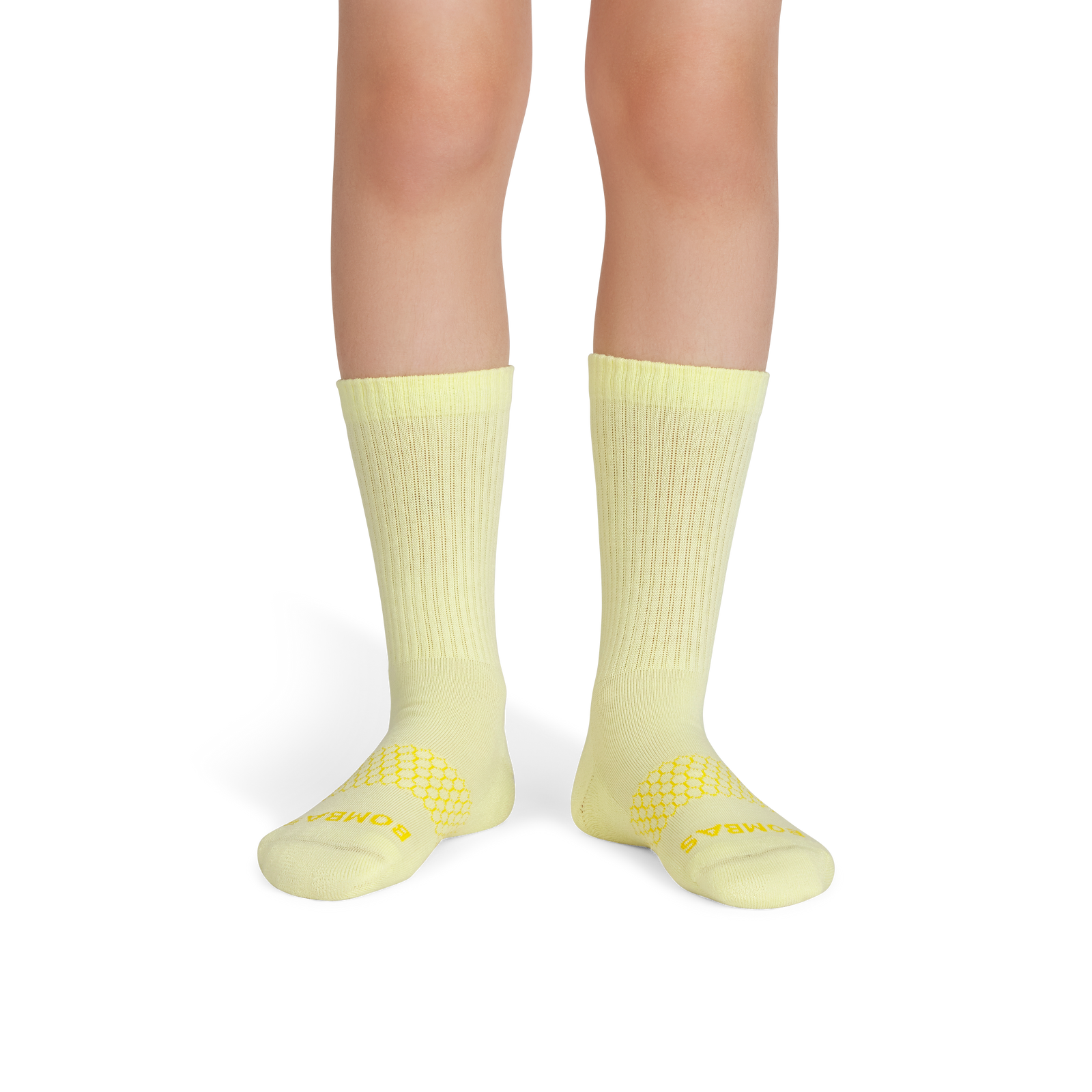 official-bombas::6570-lightmeringue-mustard-youth-unisex-onmodel-2-transparent.png